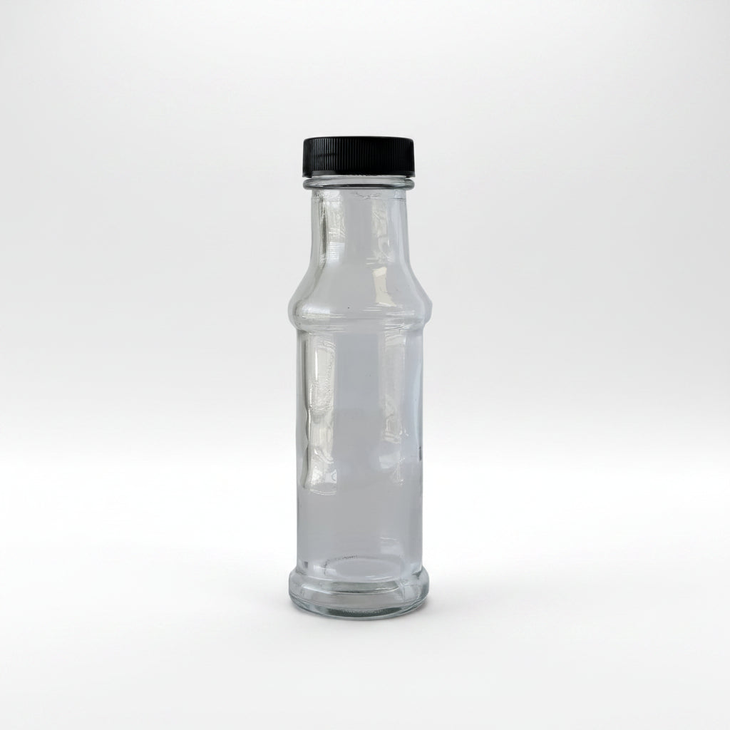 Clear glass bottle with black cap on a light gray background