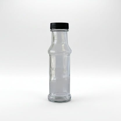 Clear glass bottle with black cap on a light gray background