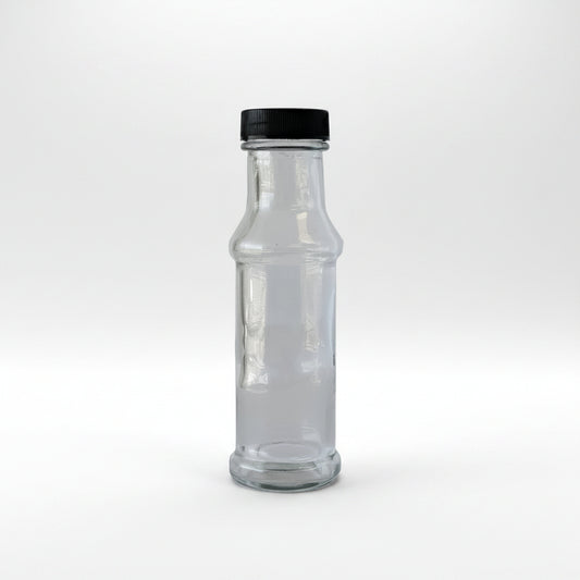 Clear glass bottle with black cap on a light gray background